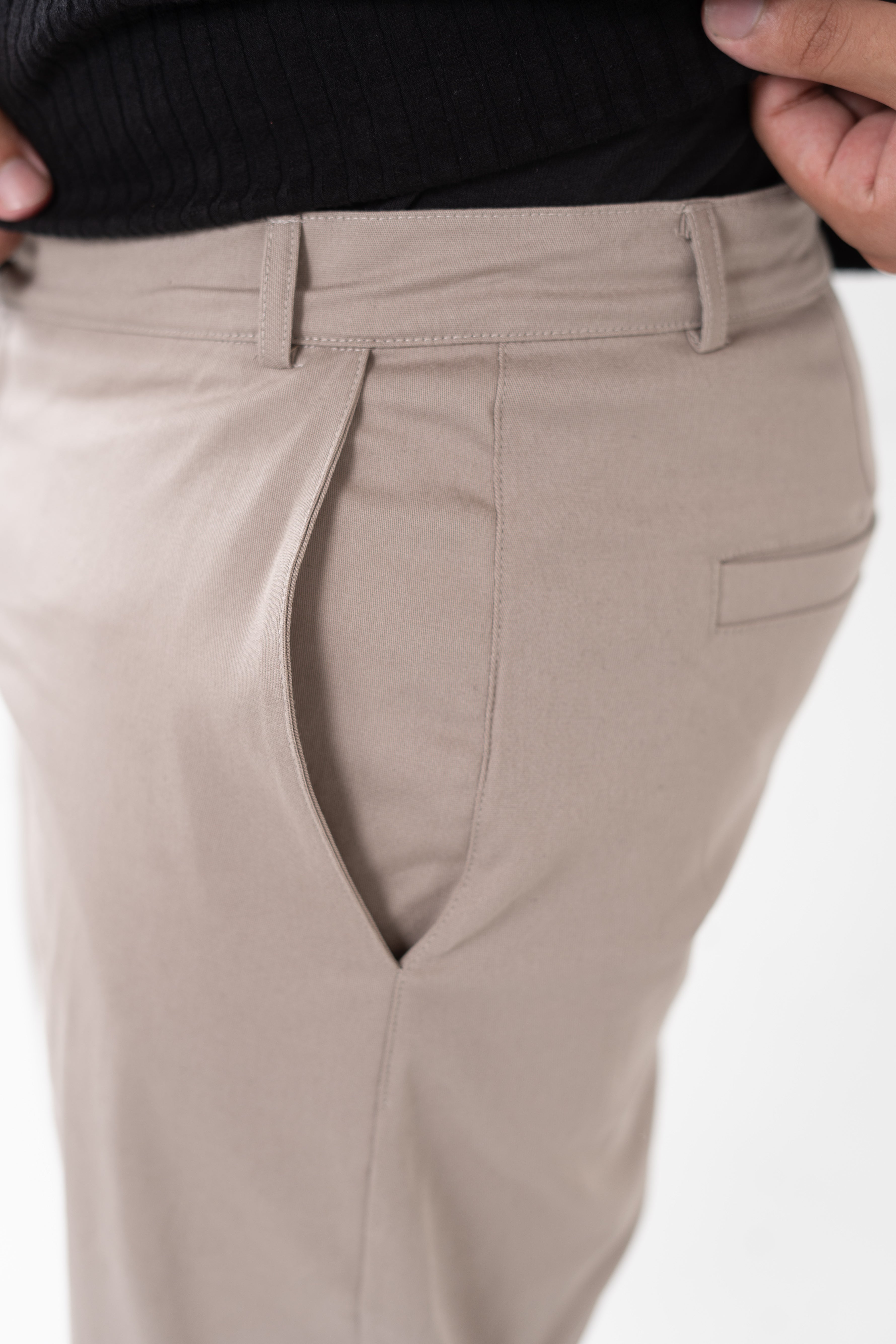 Close-up of waistband and pleated detail on men’s sand chinos