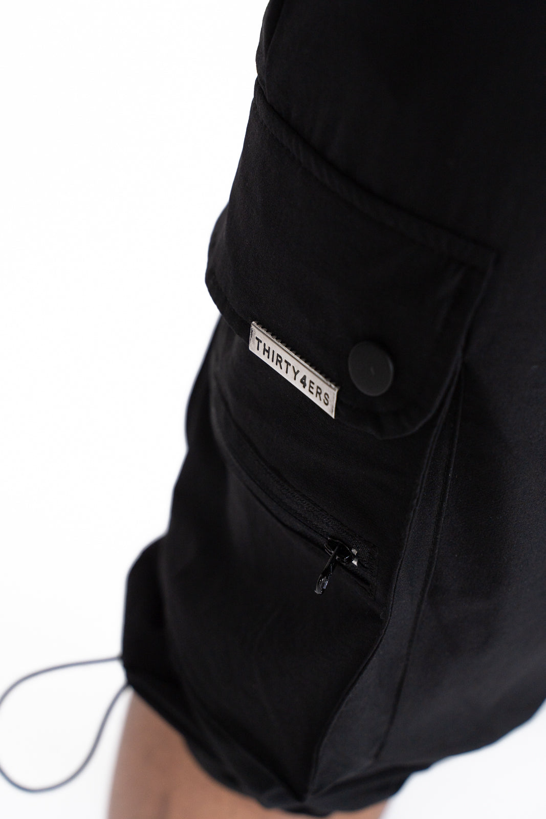 Close-up of rubber 34ERS® pocket logo with clear background on black fabric