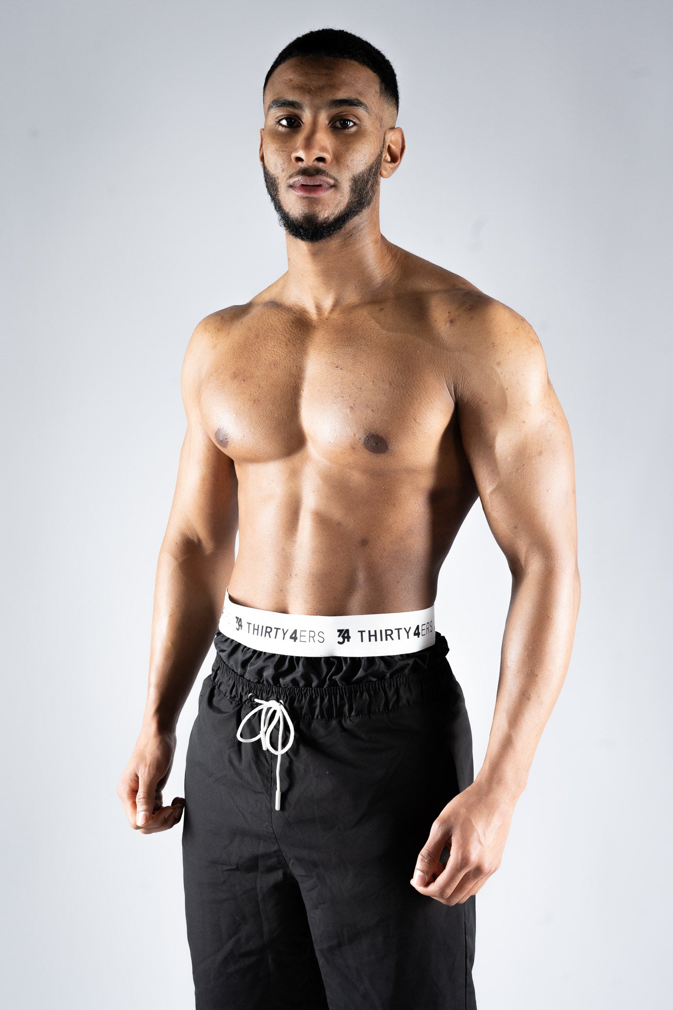 Side view of modest men’s black swim shorts with knee coverage

