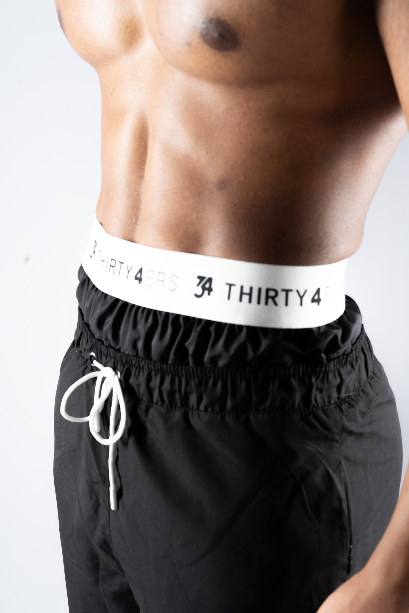 Close-up of stretch waistband with 34ERS® branding and drawstring detail

