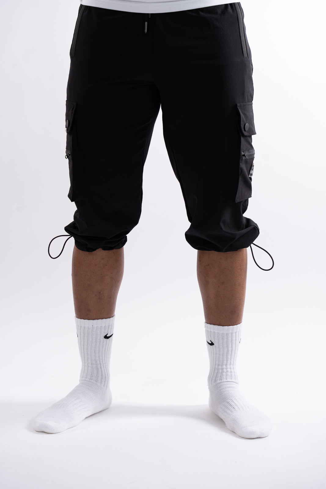 Front view of black 3/4 cargo pants for men with drawstring hem and elastic waistband