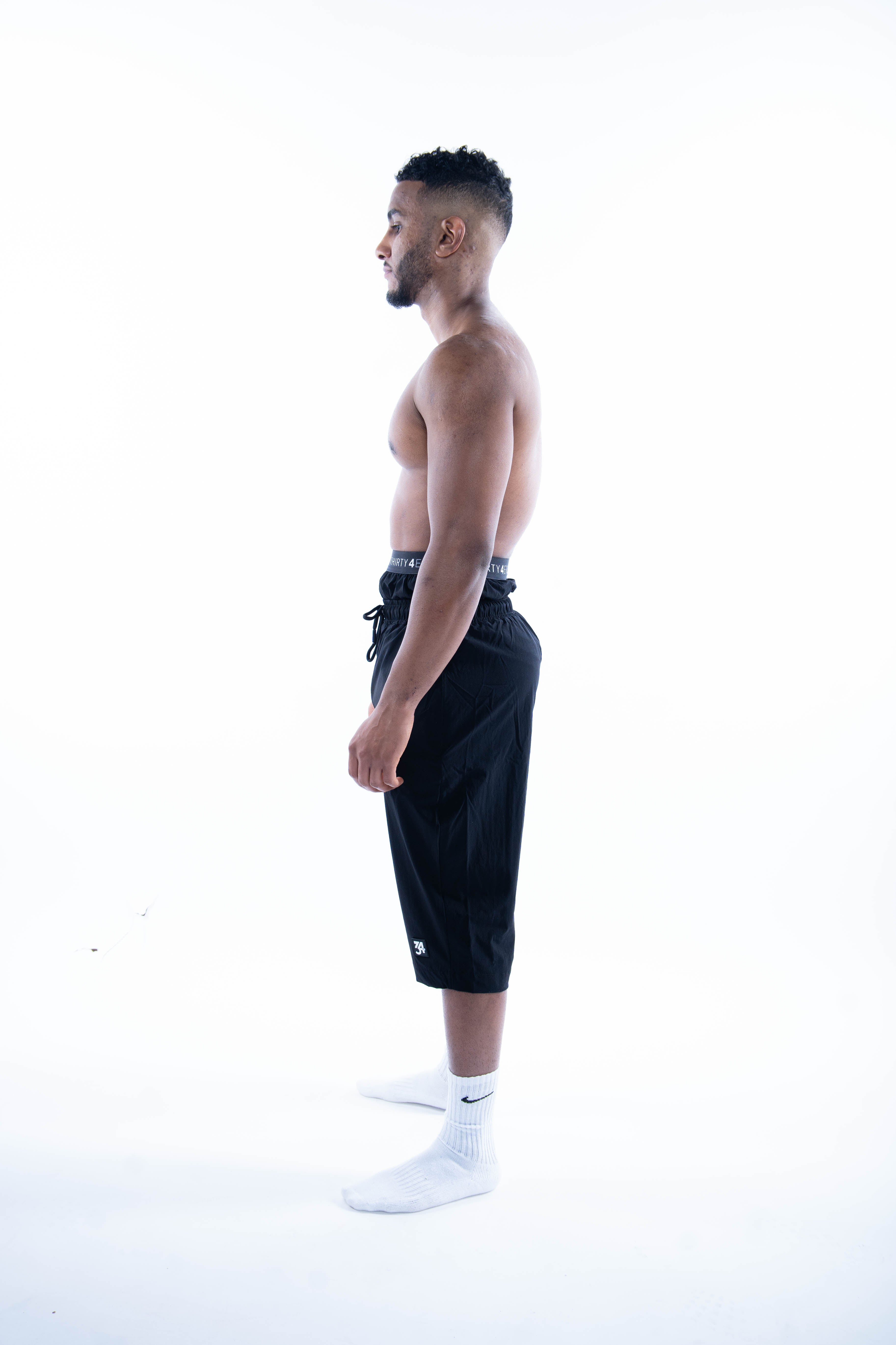 Side profile showing subtle black waistband and modest coverage for swimwear

