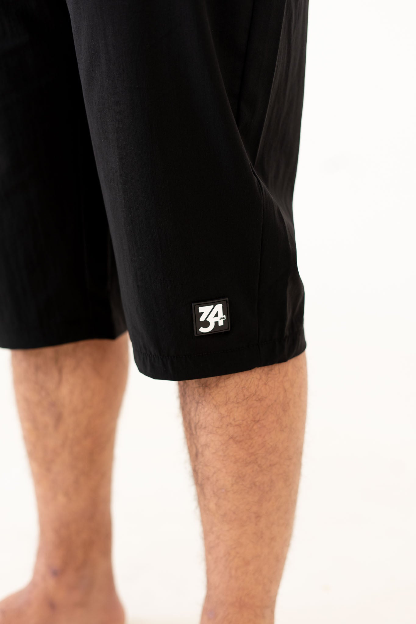 Close-up of 3D rubber-textured 34ERS® logo on AWRA shorts

